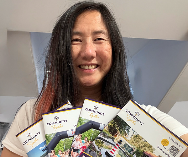 Therese Cooklin, Managing Director of Community Together, holding a fan of the latest Community Together magazines